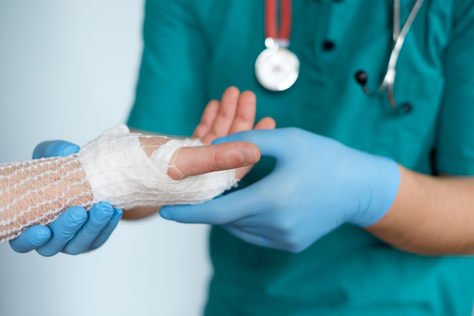 close up of doctor bandaging one hand after an accident